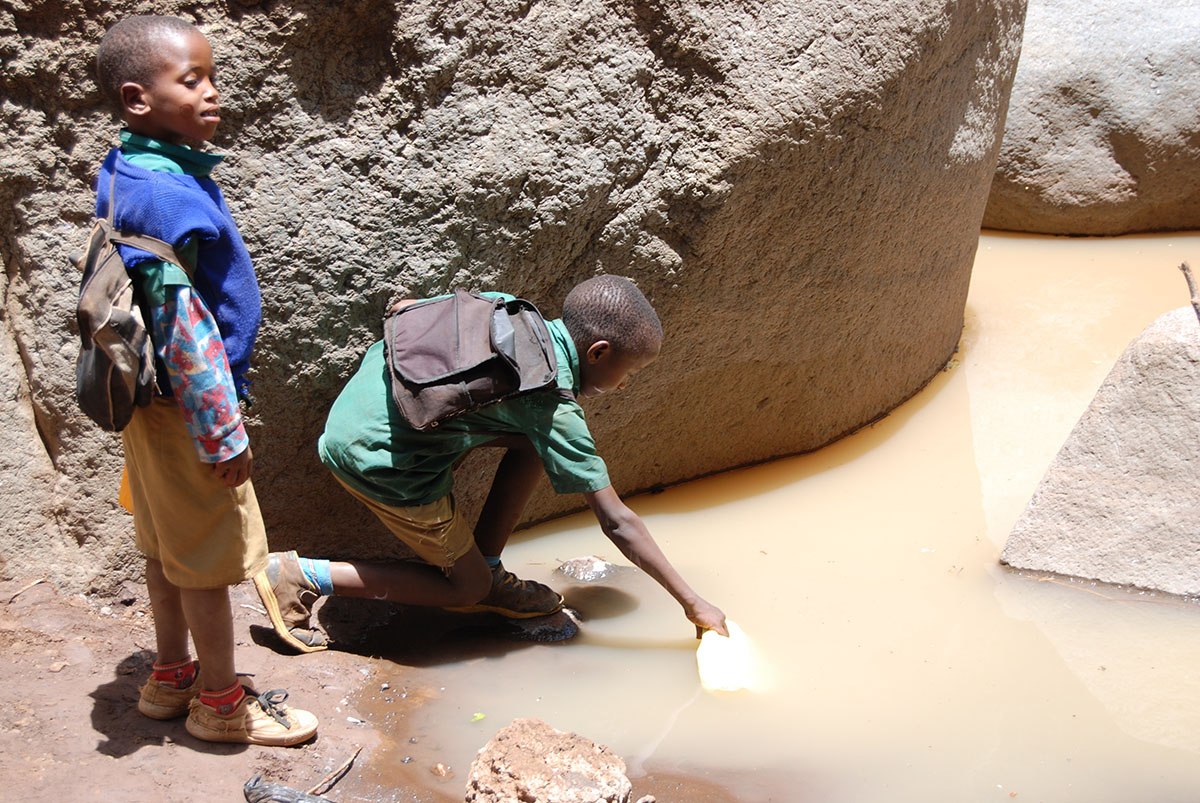 Boys Collecting Water from Contaminated River